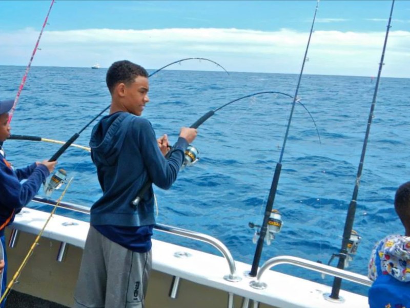 Kids enjoying deep sea fishing aboard a 49' PowerCat Boat Rental in Riviera Beach Florida.