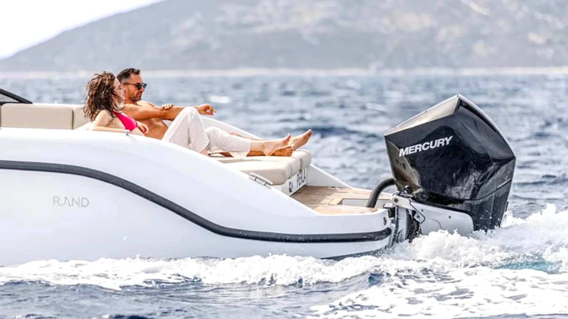 Couple relaxing in the aft lounge aboard a 29' RAND Boat Rental while enjoying a scenic day on the water.
