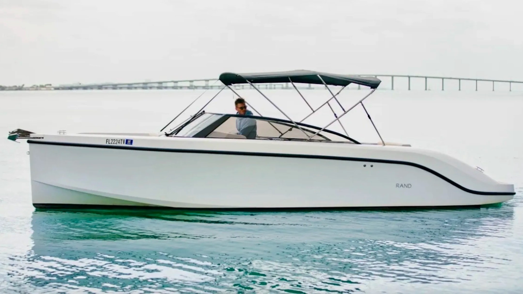 Side profile of a 29' RAND Boat Rental with extended sunshade cruising the waterways of Riviera Beach, Florida.