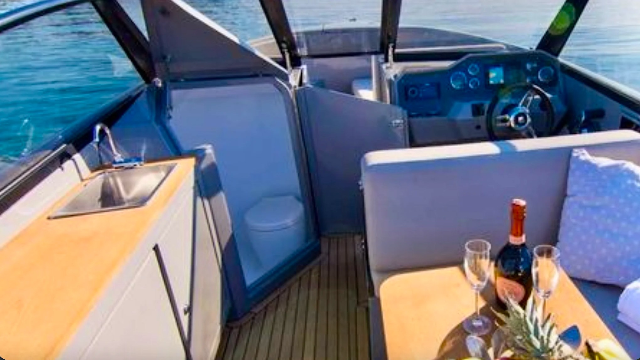 Helm station, wet bar and private marine toilet aboard a 29' RAND Boat Rental in Riviera Beach, Florida.