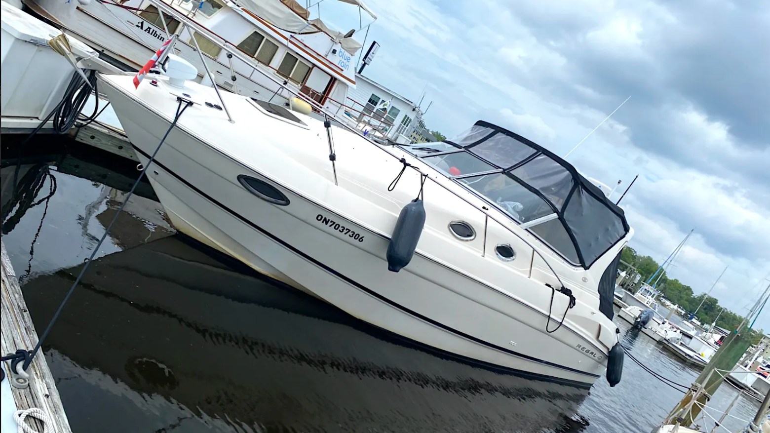 33' Regal Boat Rental docked at a Jacksonville marina with enclosed cockpit and sleek white hull.