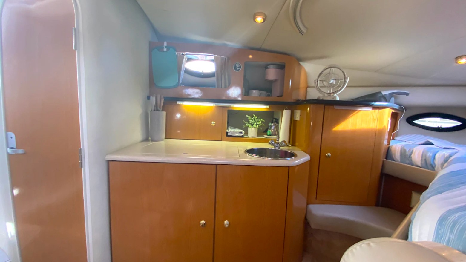 33' Regal Boat Rental cabin with galley, sink, wood cabinetry and sleeping area in Jacksonville, Florida.