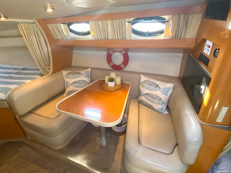 39' Regal Boat Rental cabin with wraparound salon seating, dining table and sleeping area in Jacksonville, Florida.