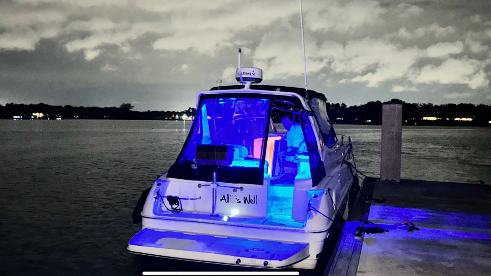 33' Regal Boat Rental illuminated with blue cockpit lighting at night on the waterfront in Jacksonville, Florida.