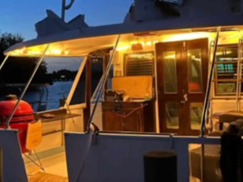 Illuminated aft deck and covered outdoor entertaining area aboard a 53' Hatteras Yacht Charter in Key West, Florida.