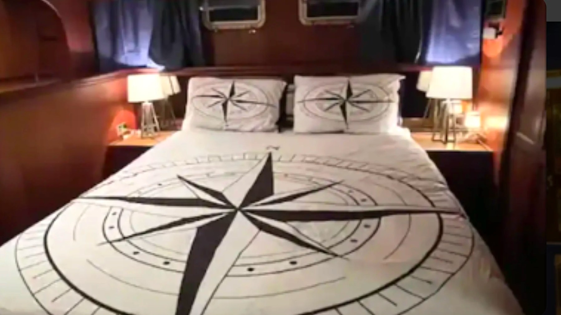 Private stateroom with double bed and nautical compass bedding aboard a 53' Hatteras Yacht Charter in Key West, Florida.
