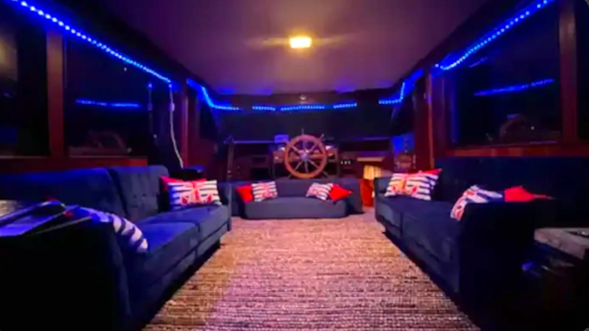 Spacious salon with blue ambient lighting and lounge seating aboard a 53' Hatteras Yacht Charter in Key West, Florida.