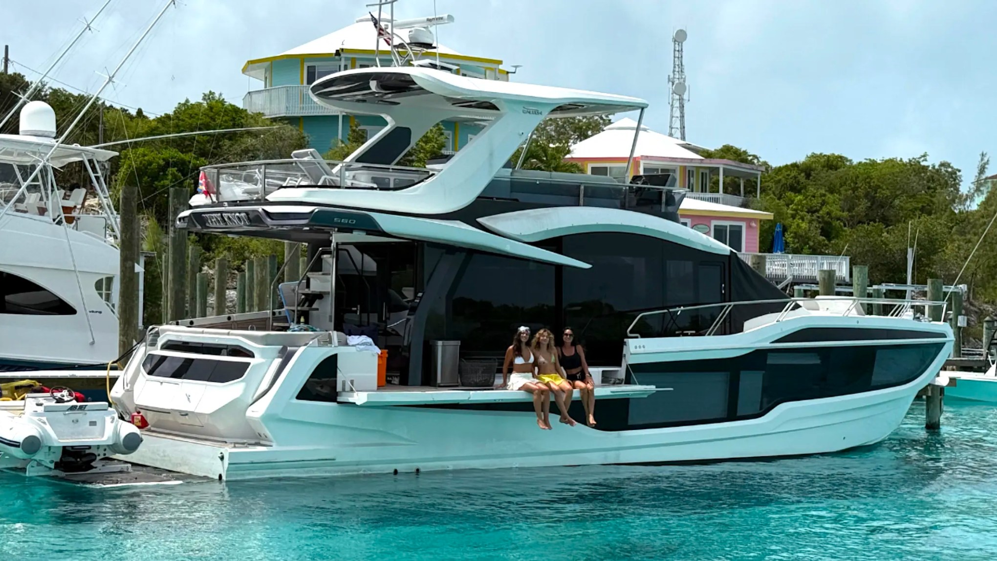 58' Galeon Yacht Charter with guests relaxing on the fold-out side terrace in Fort Myers, Florida.