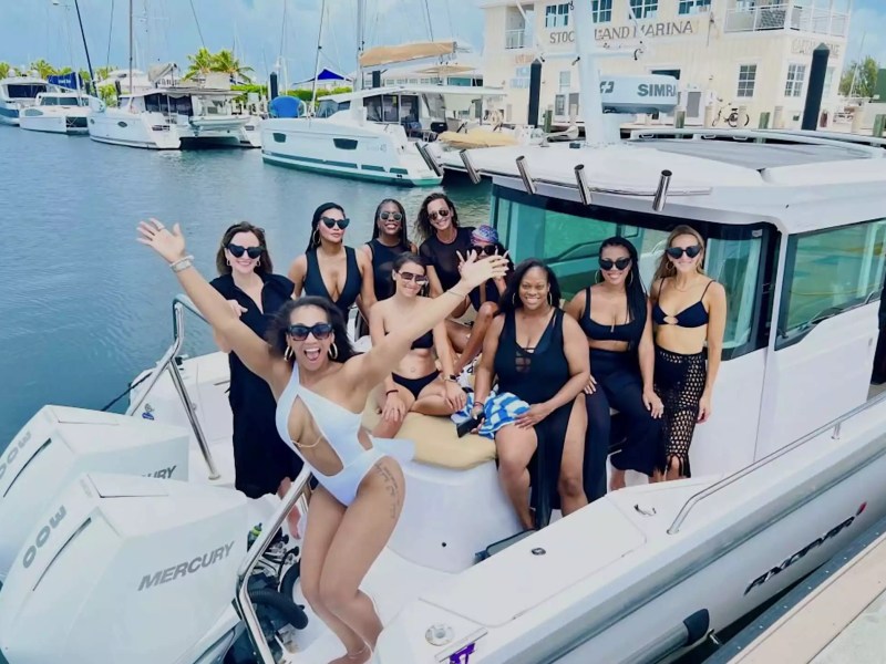 Group of friends celebrating aboard an Axopar cabin boat at Stock Island Marina in Key West, Florida.