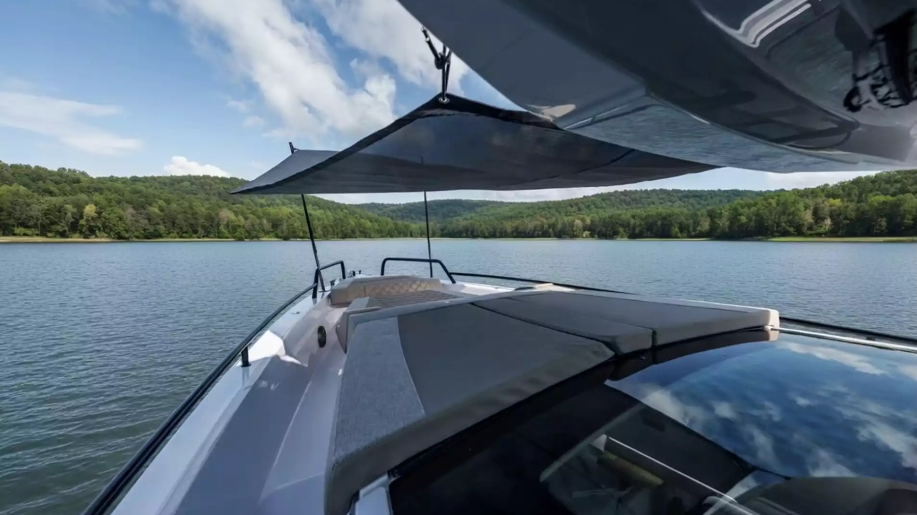 Axopar Boat Rental bow lounge with sunshade, cushioned sunpad and panoramic waterfront views.
