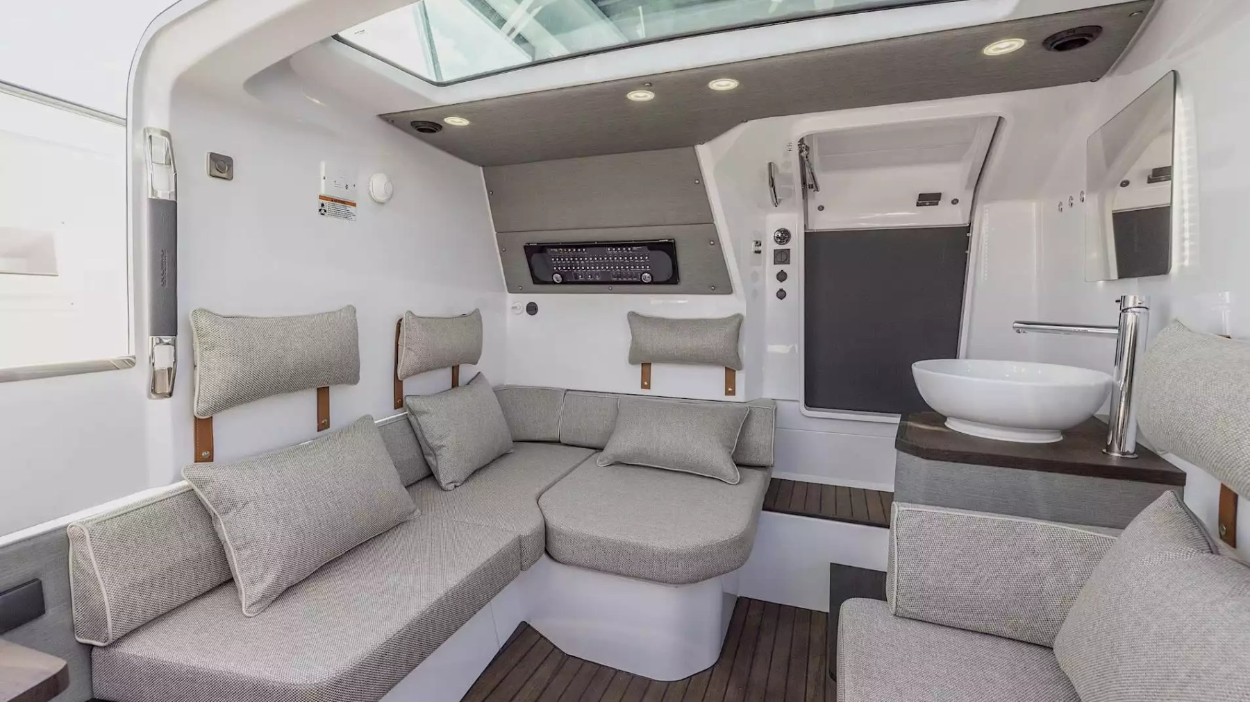 Axopar Boat Rental cabin lounge with wraparound seating, vanity and overhead skylight.