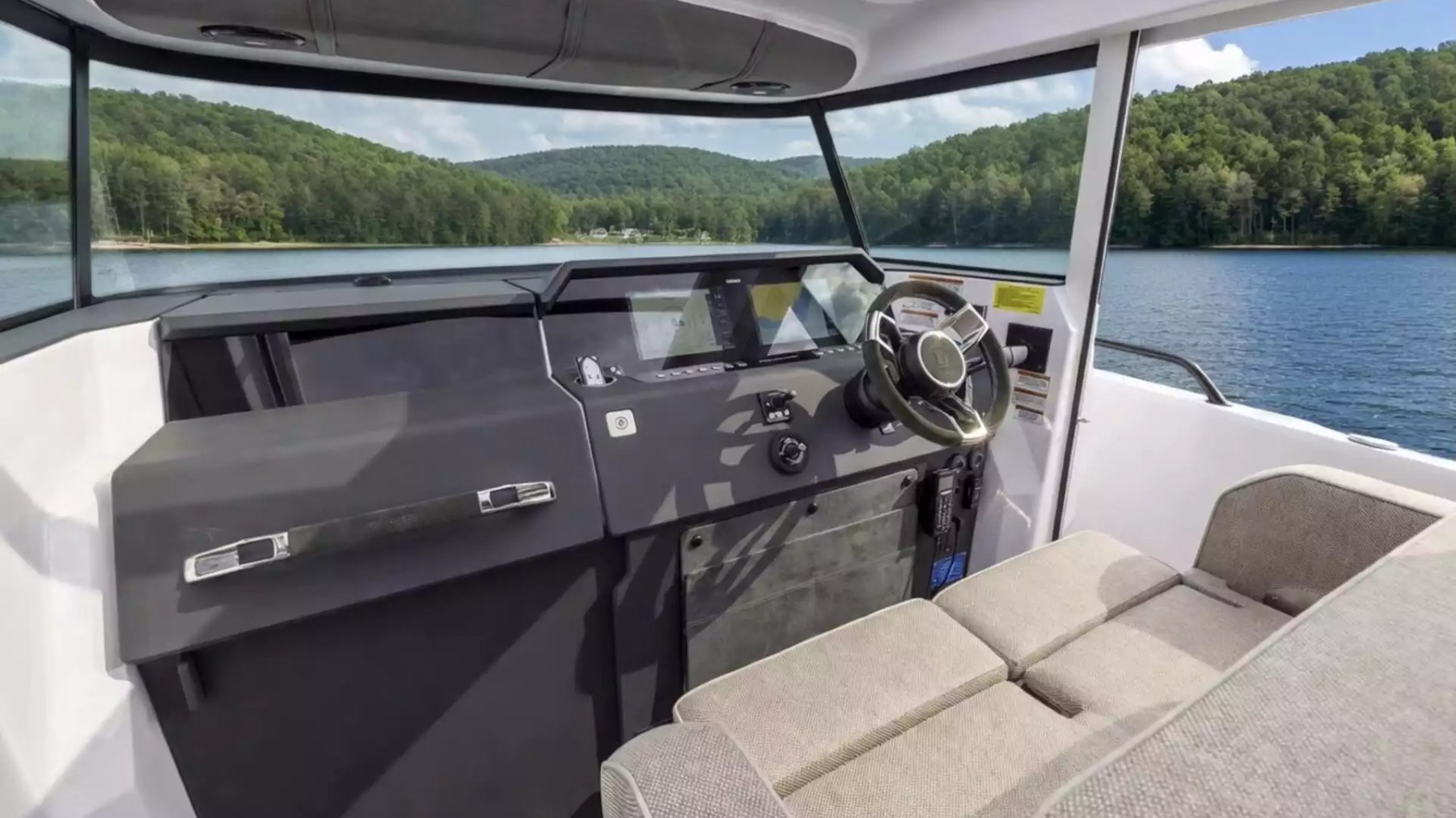 Axopar Boat Rental helm with navigation displays, panoramic windshield and comfortable seating overlooking the water.