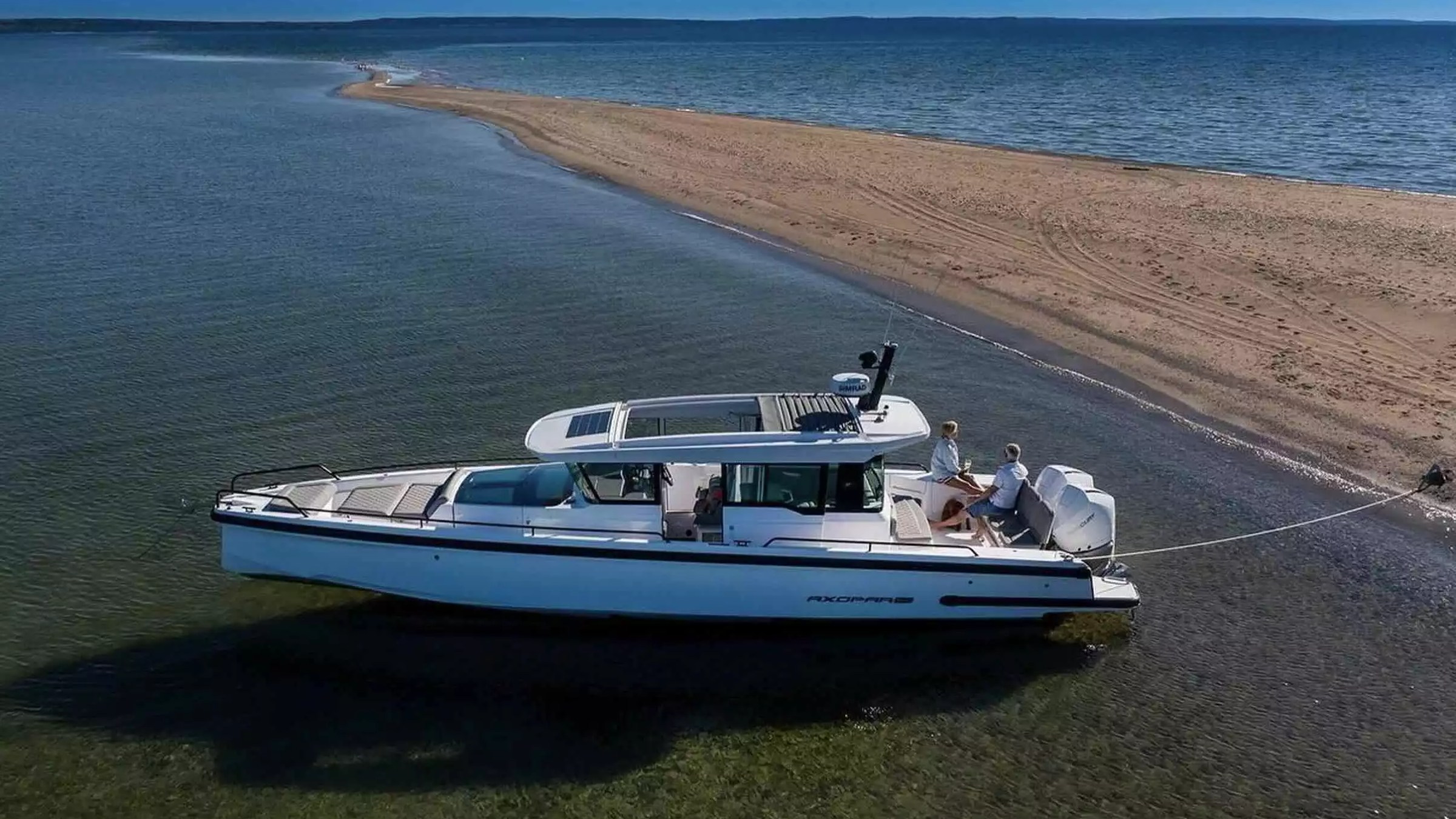 Axopar Boat Rental anchored beside a scenic sandbar with guests enjoying calm shallow water and open coastal views.