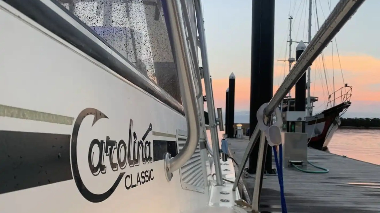 Key West Sportfishing Boat Rental docked at sunset with Catolina Classic logo and waterfront marina views.