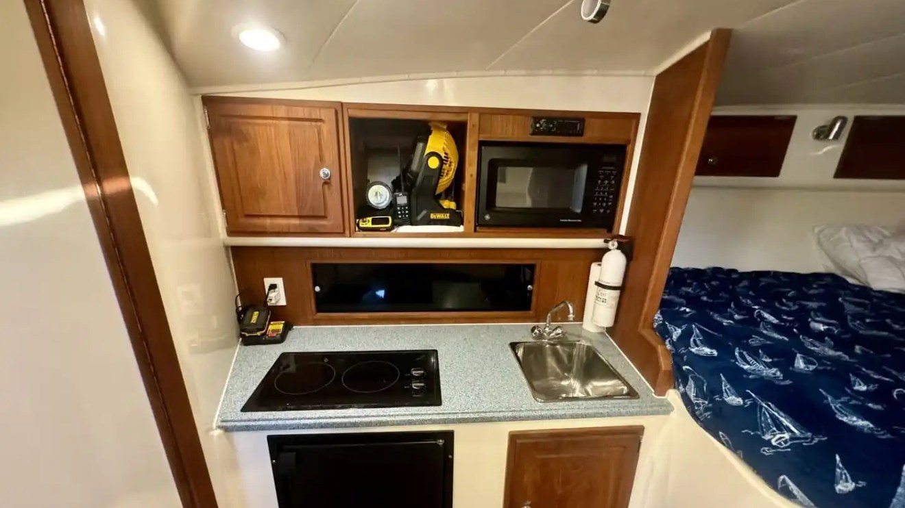 Key West Sportfishing Boat Rental cabin galley with cooktop, sink, microwave and private berth.