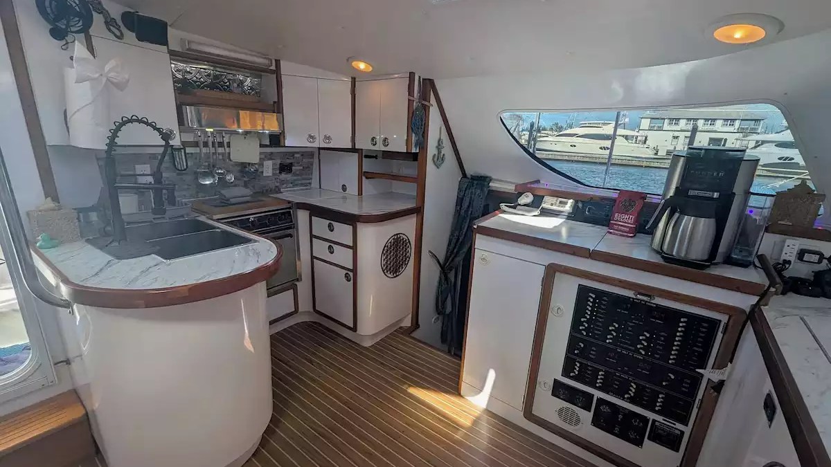 Sailing catamaran galley with full kitchen, spacious counters, sink, storage and natural light from an overhead hatch.