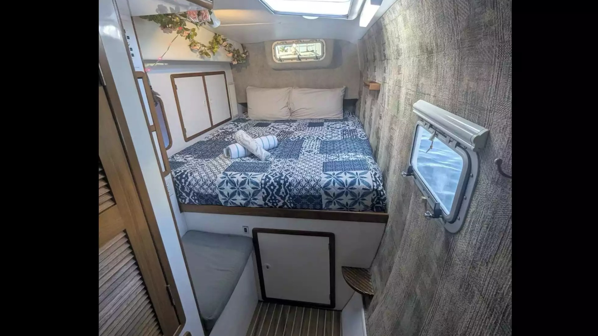 Sailing catamaran private stateroom with double berth, skylight, portholes and fresh linens.