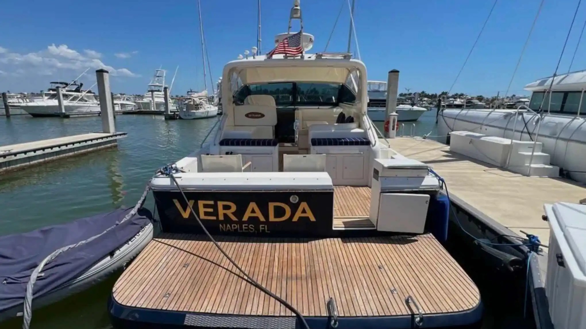44' Uniesse Boat Rental with teak swim platform and spacious aft cockpit docked in Naples, Florida.