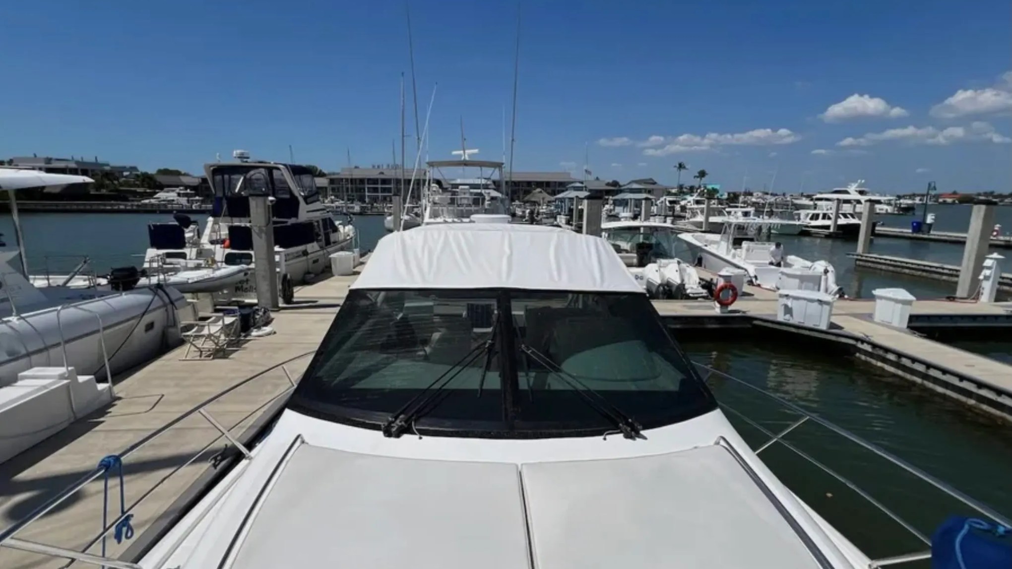 44' Uniesse Boat Rental with spacious bow sun pad at a marina in Naples, Florida.