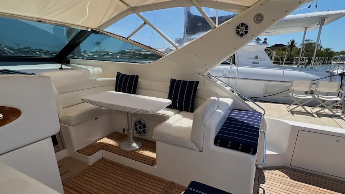 44' Uniesse Boat Rental with covered cockpit dining lounge and teak deck in Naples, Florida.