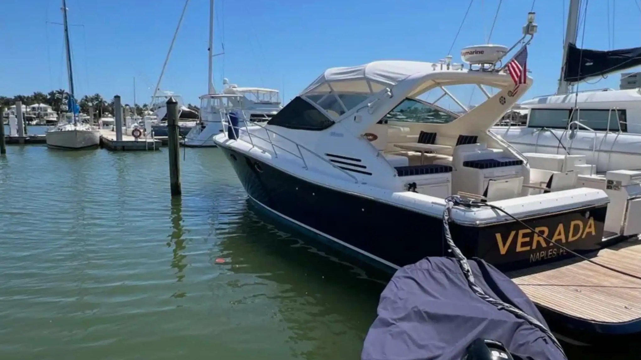44' Uniesse Boat Rental docked at a Naples marina with spacious aft cockpit and swim platform in Florida.