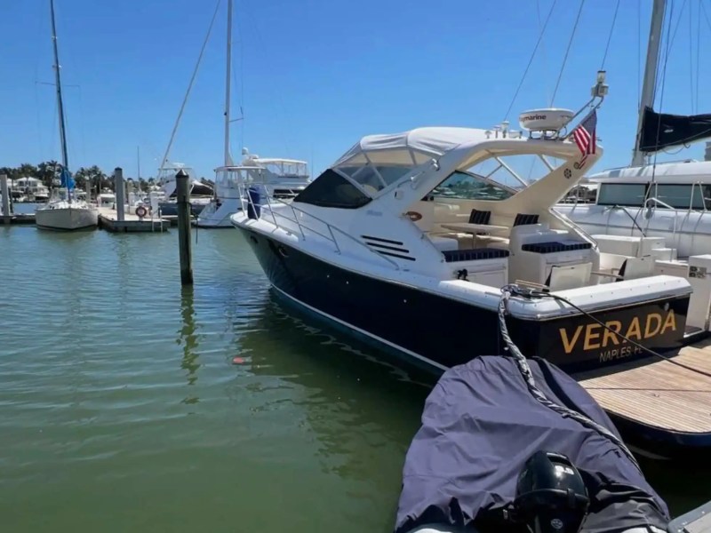 44' Uniesse Boat Rental docked at a Naples marina with spacious aft cockpit and swim platform in Florida.