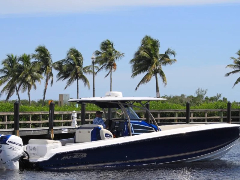Nor-Tech Boat Rental with twin Mercury outboards cruising past palm trees in Southwest Florida.