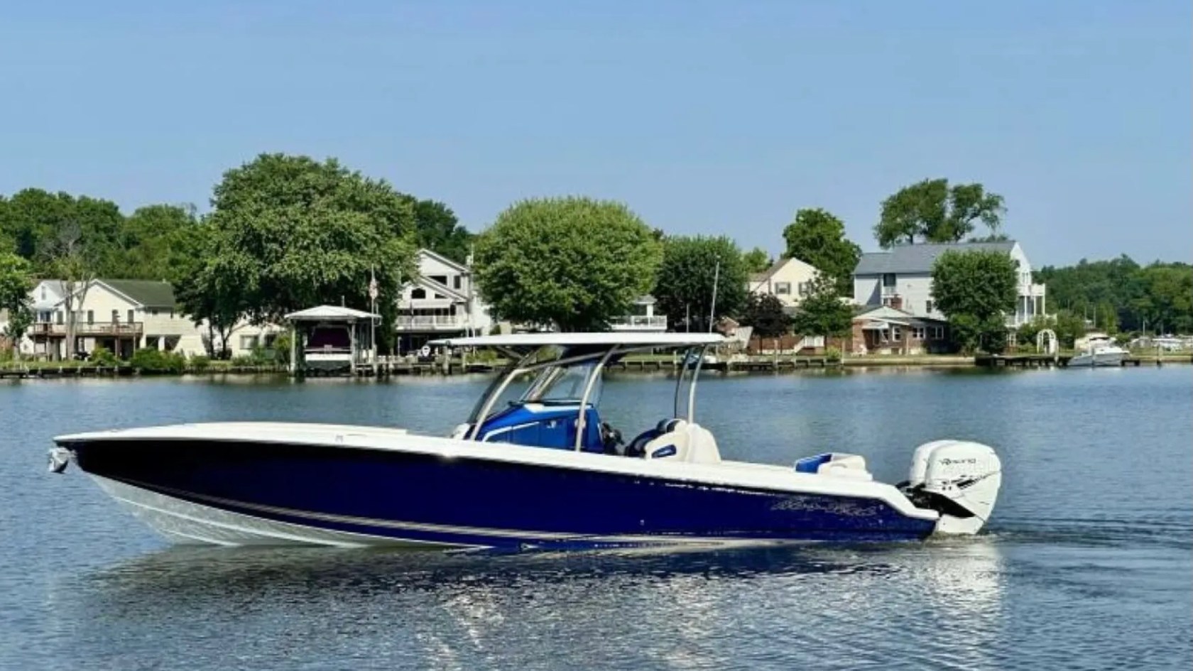 Nor-Tech Boat Rental with deep blue hull, center console and hardtop cruising along a scenic Florida waterfront.