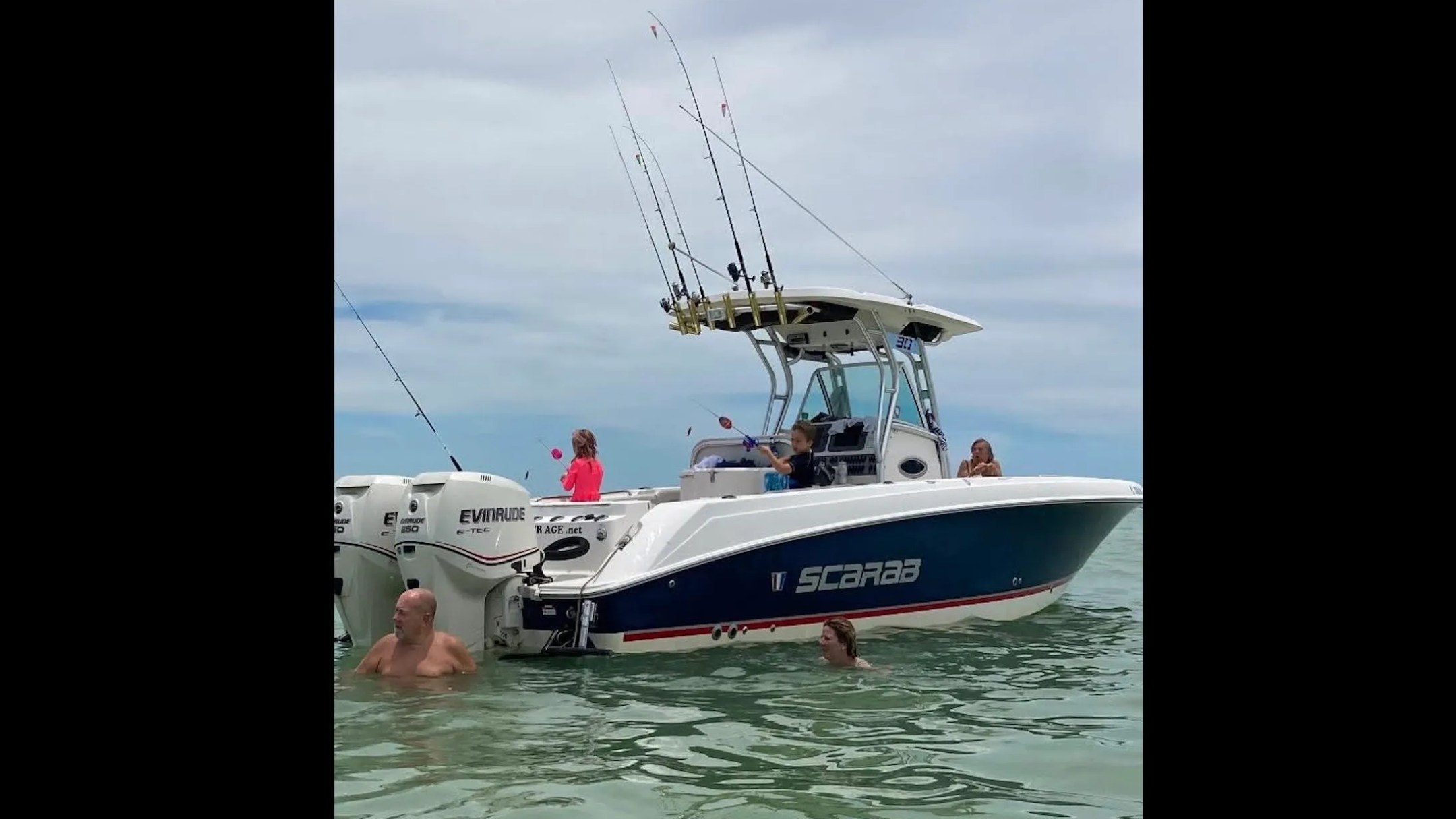 Scarab Boat Rental with fishing rods and guests swimming in shallow South Florida waters.