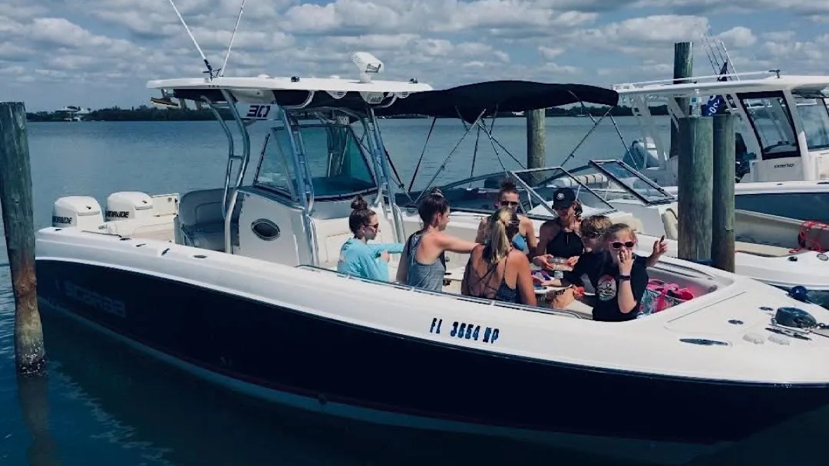 Scarab Boat Rental with friends enjoying bow seating and refreshments on the water in South Florida.