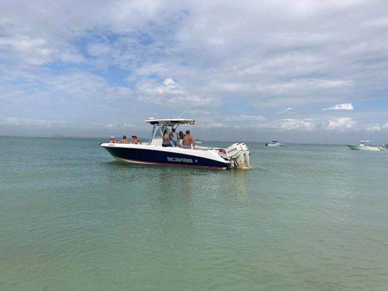 Scarab Boat Rental anchored in shallow tropical water with guests enjoying a South Florida sandbar outing.
