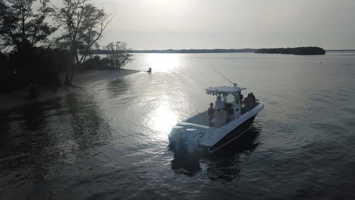 Scarab Boat Rental anchored near a quiet South Florida shoreline with guests enjoying an evening on the water.