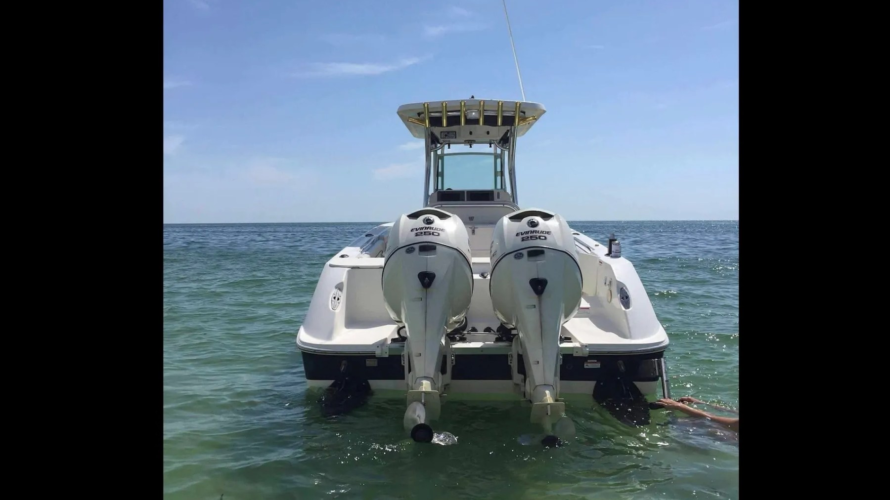 Scarab Boat Rental with twin 250 HP Evinrude outboards anchored in clear South Florida water.