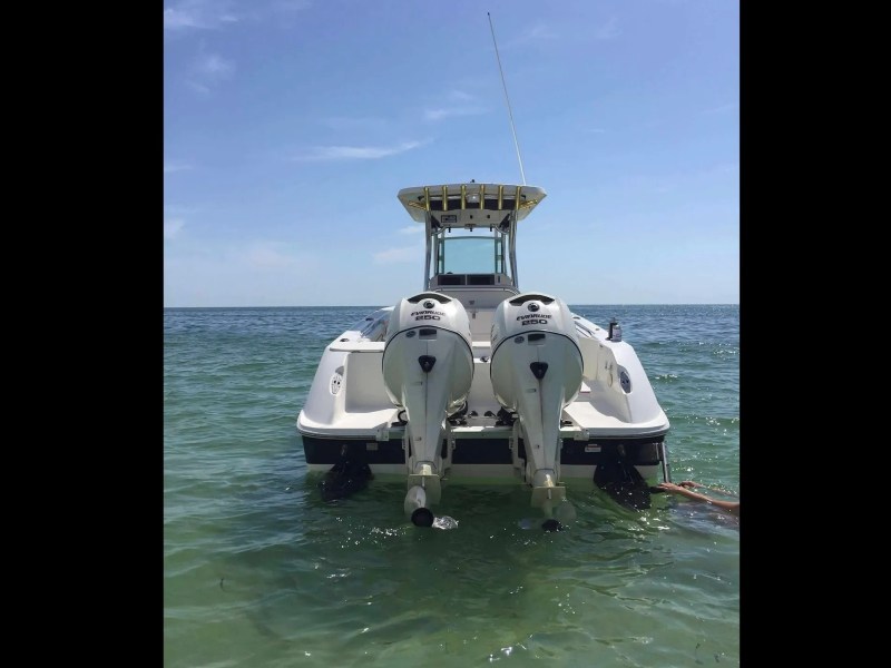 Scarab Boat Rental with twin 250 HP Evinrude outboards anchored in clear South Florida water.